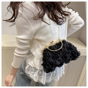 Detail of black chiffon 3D rose evening bag with gold chain and metal clasp closure