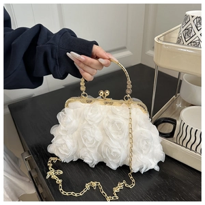 Detail of white 3D rose evening bag with gold metal handle and intricate floral texture