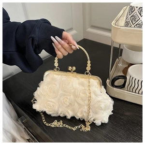 Detailed close-up of cream chiffon rose petals and golden metal handle on evening clutch