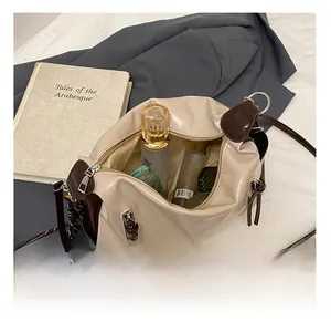 Detail view of large beige tote interior storage with cosmetics and tassel zipper