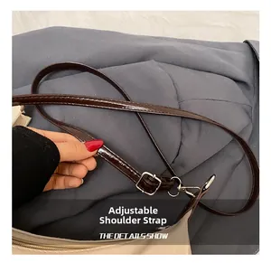 Close-up of adjustable dark brown glossy strap with silver metal buckle and hook