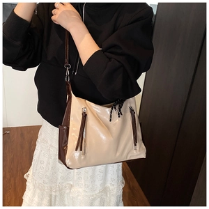 Detail view of the contrasting cream and brown PU leather handbag with decorative zippers