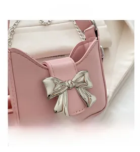 Nahaufnahme der rosa Mini-Tasche aus PU-Leder mit silberner Schleife und Kettenriemen