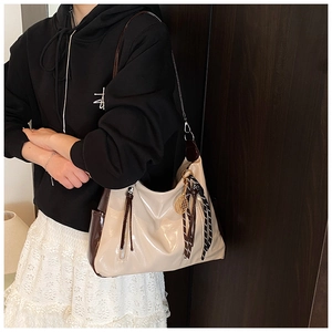 Detailed view of bicolor tote bag with tennis racket charm and woven rope detail