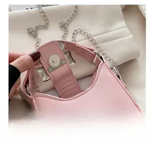 Detailaufnahme des silbernen Magnetverschlusses an einer rosa Mini-Handtasche aus Leder