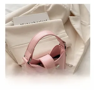 Nahaufnahme der rosa Mini-Umhängetasche mit silberner Schleife und Metallkette