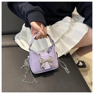 Details einer lavendelfarbenen Mini-Handtasche mit silberner Schleife und Kette