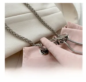 Detail of pink pleated bucket bag featuring silver metal chain and eyelet drawstring