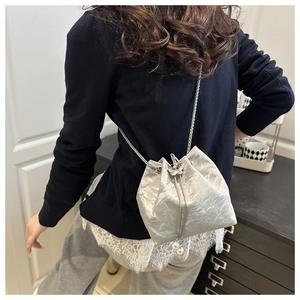 Silver bucket bag with metal chain strap, butterfly charm and pearl drawstrings