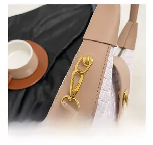 Detail of pink woven leather bag with gold metal hardware and elegant chain attachment