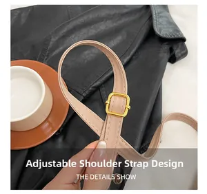 Detail of adjustable leather shoulder strap with gold buckle on a beige woven handbag