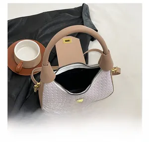 Detail show of woven texture tote bag featuring a spacious interior and gold metal clasp