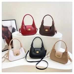 Detailed view of woven texture crossbody bags in five colors on a display stand