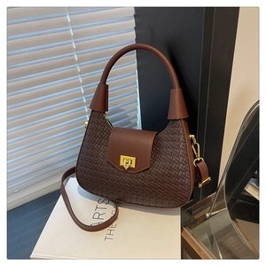 Detail of dark brown woven texture and gold rectangular buckle on the hobo crescent bag