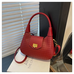 Macro detail of red woven leather moon bag with golden metal twist lock and texture