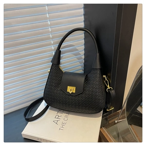 Detail shot of black woven PU leather crescent bag with golden buckle and sleek top handle