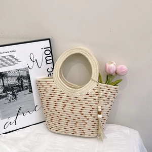 Borsa tote minimalista in paglia intrecciata a pois marroni con nappine in legno