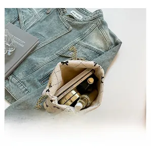 Internal storage view of corduroy crossbody bag with bow pattern and metal chain