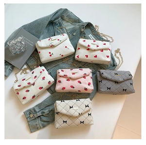 Close-up of corduroy crossbody bags with assorted floral prints and chain straps
