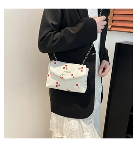 Detail of corduroy crossbody bag with cherry embroidery and gold chain strap