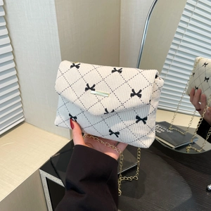 White corduroy crossbody bag with diamond pattern, bow accents and gold chain strap