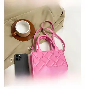 Quilted PU leather small tote in bright pink shown next to a smartphone for scale