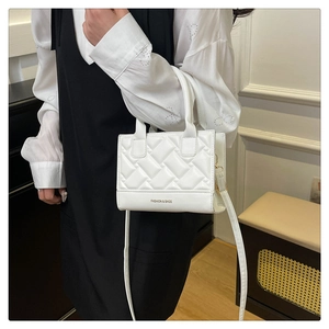 Close-up of quilted white PU leather crossbody bag with FASHION & BAGS logo detail