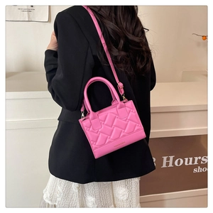 Detail of rose pink quilted PU crossbody bag showing the woven texture and fashion logo