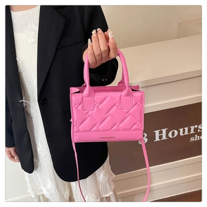 Detail of pink quilted square bag with woven texture and Fashion & Bags lettering