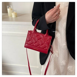 Red quilted PU leather crossbody bag with top handle shown on model in stylish setting