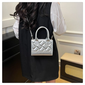 Detail view of silver quilted PU handbag with adjustable strap and bottom embossed logo