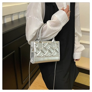 Fashionable silver PU crossbody bag with quilted lattice texture worn by a model