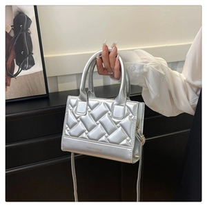Detail of silver quilted PU handbag with metallic finish and long shoulder strap