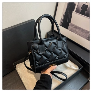 Detailed macro view of black quilted PU leather handbag with gold Fashion and Bags text