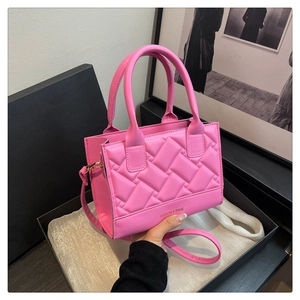 Close-up of pink quilted faux leather handbag with golden Fashion & Bags logo detail
