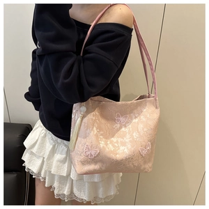 Close-up of pink brocade tote bag with 3D butterfly embroidery and silk tassel detail