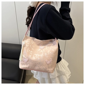 Detail of pink jacquard tote bag with butterfly embroidery and pearl tassel ornament