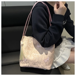 Detail of embroidered tote bag with 3D butterfly appliques and pearl tassel accessory