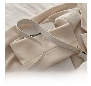 Détails du sac à bandoulière en cuir blanc avec sangle et boucle en métal doré
