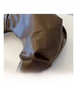 Detail view of the pleated dark brown PU leather texture and premium sewing on the bag