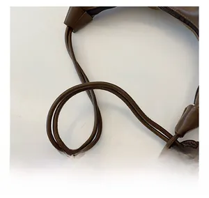 Detail of soft brown PU leather shoulder bag featuring stylish double-knotted cord handles