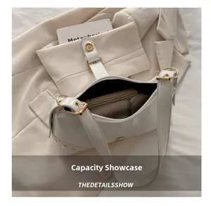 Vue de la capacité du sac hobo minimaliste en cuir blanc avec rivets et boucles