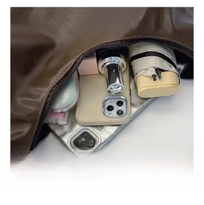 Detail view of large capacity interior for brown leather bag with multiple compartments