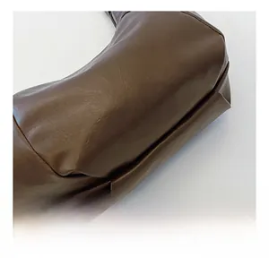 Detailed macro view of the soft dark brown PU leather texture and seamless stitching