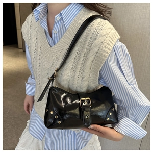 Détail du sac à bandoulière en cuir verni noir avec rivets dorés vintage et boucle