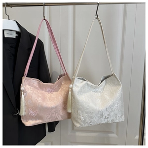 Detail of pink and cream tote bags with butterfly embroidery and velvet tassels