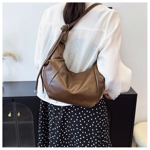 Detail of the refined knot design and soft pleated texture on the brown PU shoulder bag