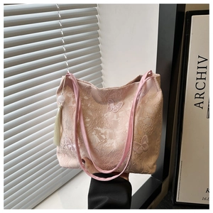 Détail du sac cabas en dentelle rose avec broderie papillon et pompon à perles