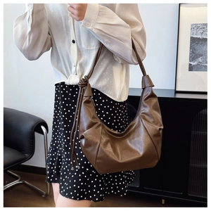 Detail of the soft brown PU leather hobo bag featuring a decorative knotted shoulder strap