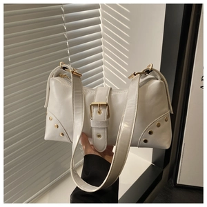 Close-up of white underarm bag featuring glossy texture and large gold metal buckle